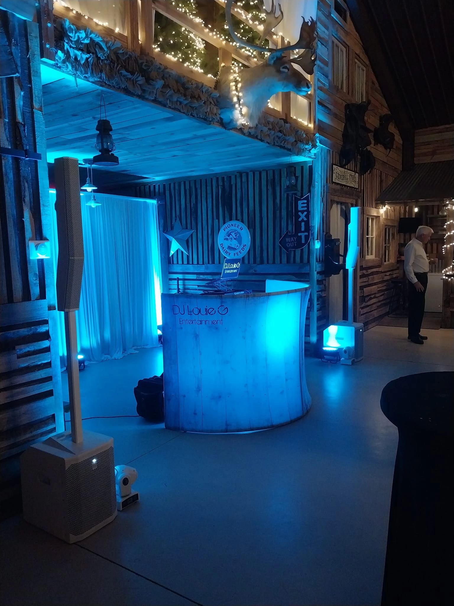 DJ booth with blue lighting in a rustic indoor setting.